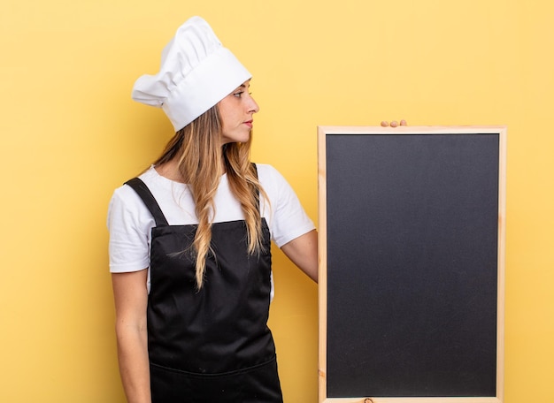 Chef-kok vrouw op profielweergave denken, verbeelden of dagdromen. schoolbord menu concept