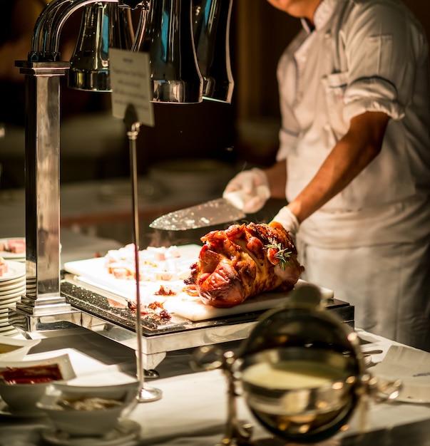 Chef-kokhand die geroosterde ham snijdt