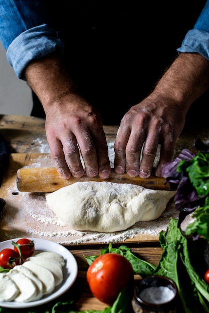 Chef-koks handen Italiaanse chef-kok pizza koken man handen pizza deeg koken voor pizza