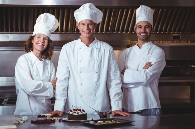 Chef-koks zijn blij en trots om de cake te presenteren die ze zojuist hebben gemaakt