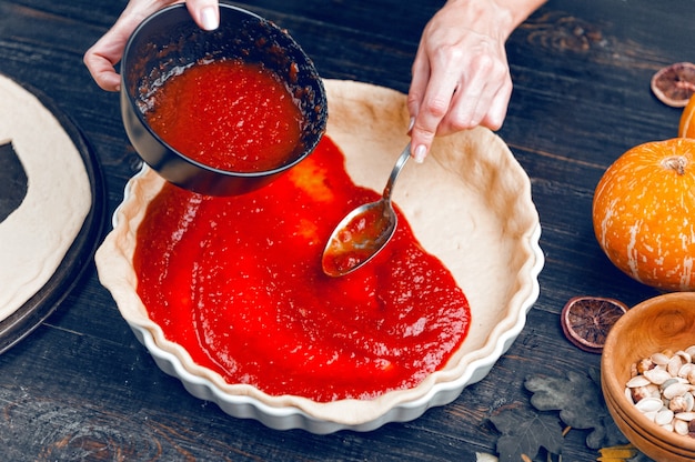 Chef kookt een taart voor Halloween met een vulling van pompoen-aardbeienjam en perziken