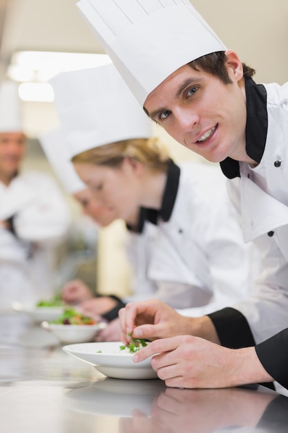 Chef looking up from preparing salad