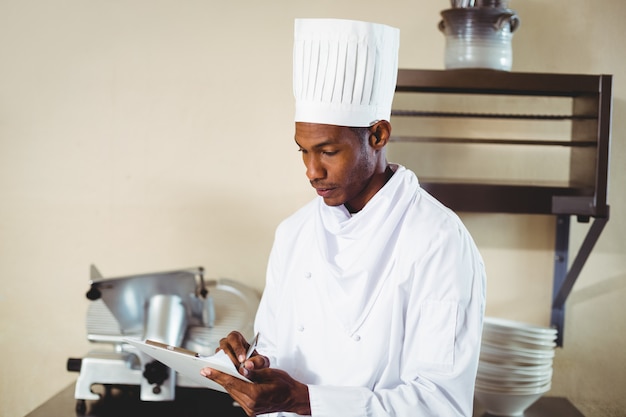 Chef making notes on a clipboard