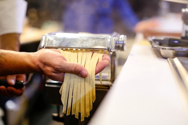 Chef making pasta with a machine, home made  fresh pasta