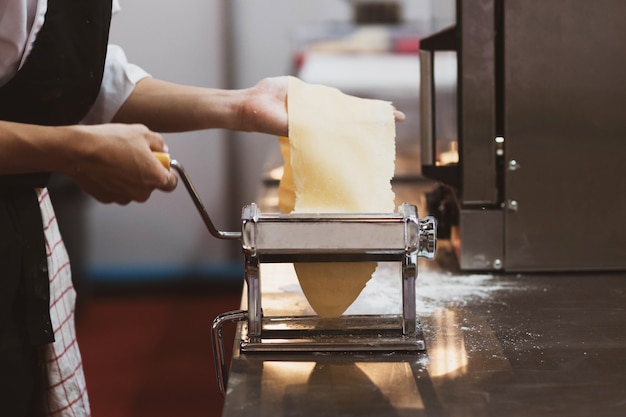 Chef making pasta with a machine, home made fresh pasta