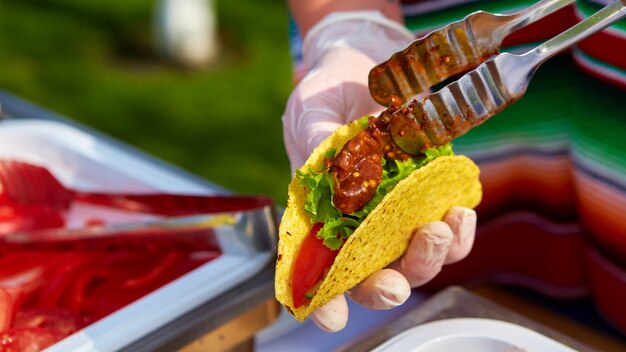 Lo chef prepara i tacos in un caffè di strada. messa a fuoco selettiva