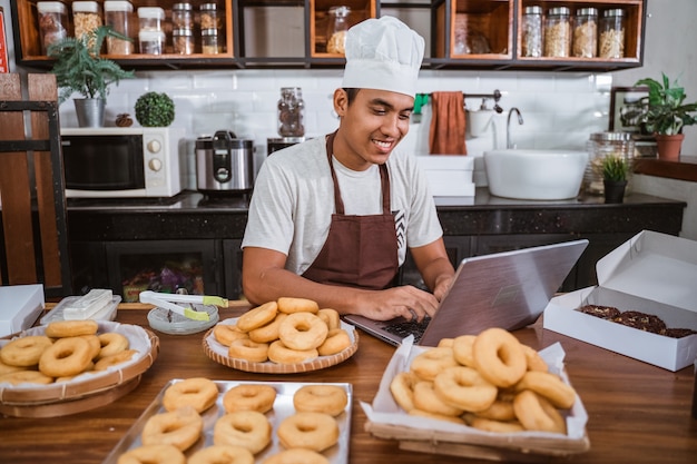 Chef male preparing donuts in the kitchen