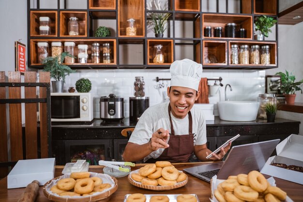 Chef male preparing donuts in the kitchen