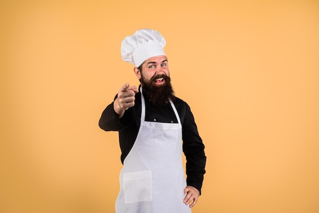 Chef man happy male chef with beard mustache shows finger on you cook points forward cook in uniform