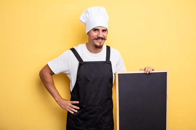 Chef man smiling happily with a hand on hip and confident