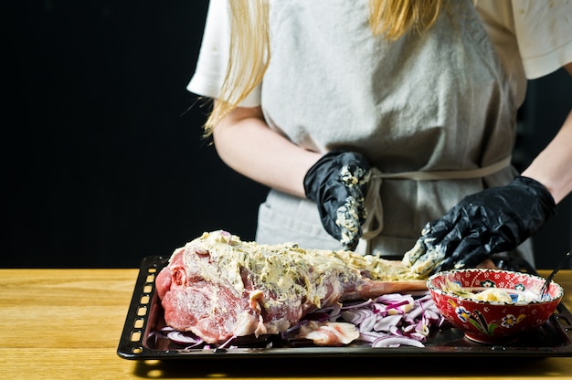 Photo the chef marinates raw goat leg.