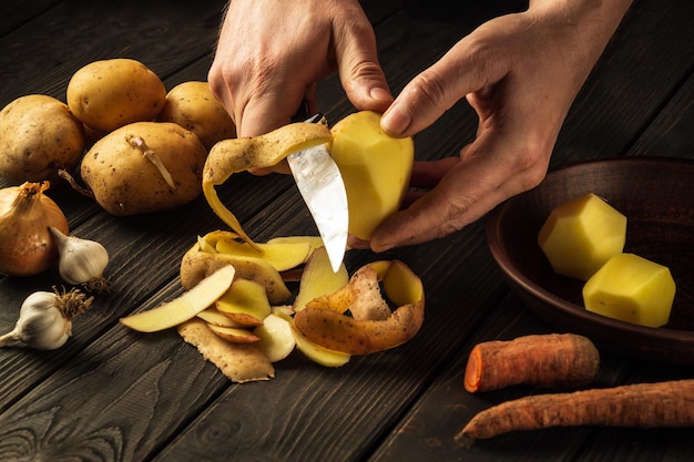 Chef peels potatoes for French fries For potato dishes