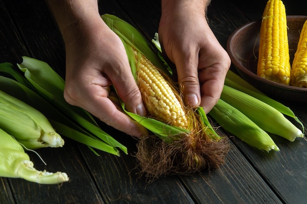 The chef peels ripe corn from the shell before cooking