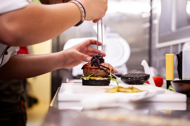 Chef performs how to make proper buger. Delicious food