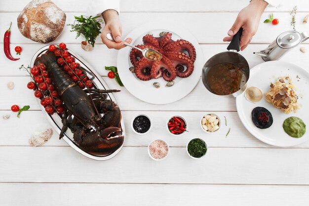 Foto chef versando il polpo con salsa speciale