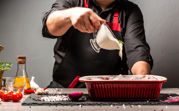 Chef pouring sour cream sauce on rabbit meat