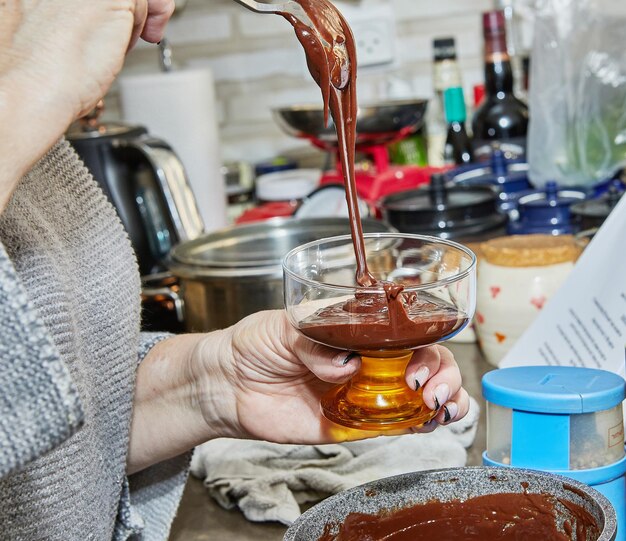 Chef pours the Pesach Special Chocolate Cream with Strawberries and Blueberries into special bowl