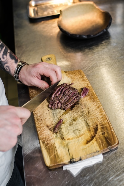 Chef prepares beef steak tenderloin in the restaurant kitchen