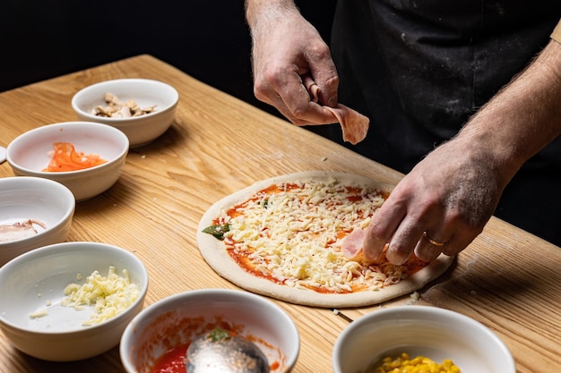 the chef prepares delicious pizza in the restaurant. Close-up