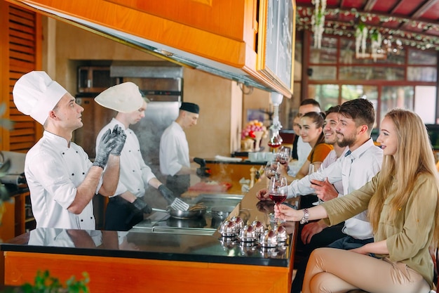 The chef prepares food in front of the visitors in the restaurant.