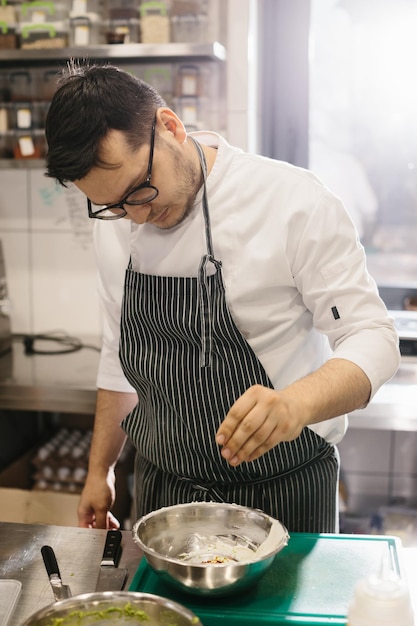 Foto lo chef prepara il cibo nella moderna e spaziosa cucina