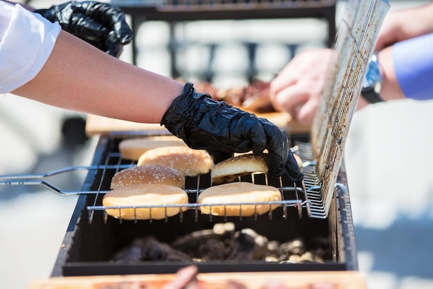 The chef prepares grilled hamburger bunsGrilled meat A piece of meat in the smoke