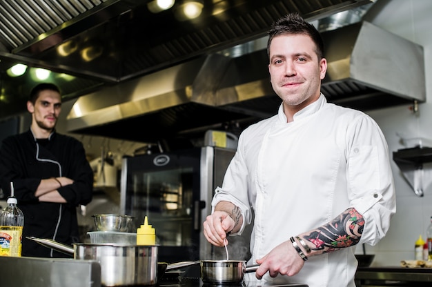 Chef prepares halibut under celery in the restaurant kitchen