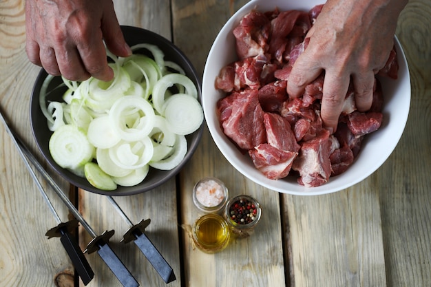 シェフがバーベキュー用の肉を準備しますボウルに肉片を入れます