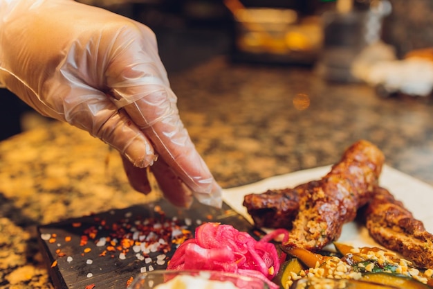 The chef prepares meat on the barbecue