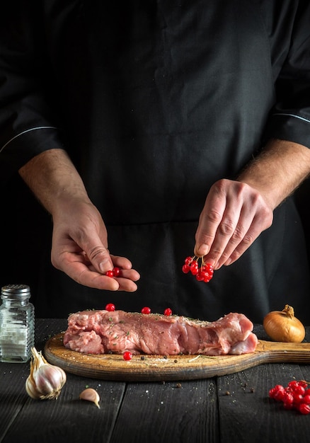 The chef prepares raw veal meat