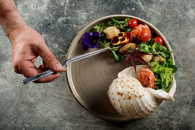 Photo the chef prepares a salad of seafood and vegetables