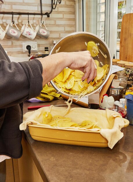 Chef prepares souffle of potatoes zucchini cauliflower and yellow cheese according to French recipe