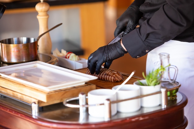 The chef prepares a steak in the restaurant hall