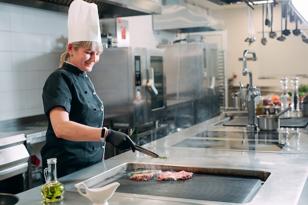 The chef prepares a steak in the restaurant's kitchen