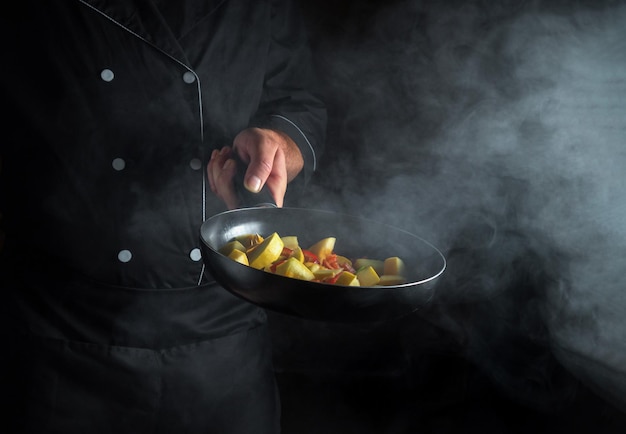 The chef prepares vegetables in a frying pan Cooking healthy vegetarian food