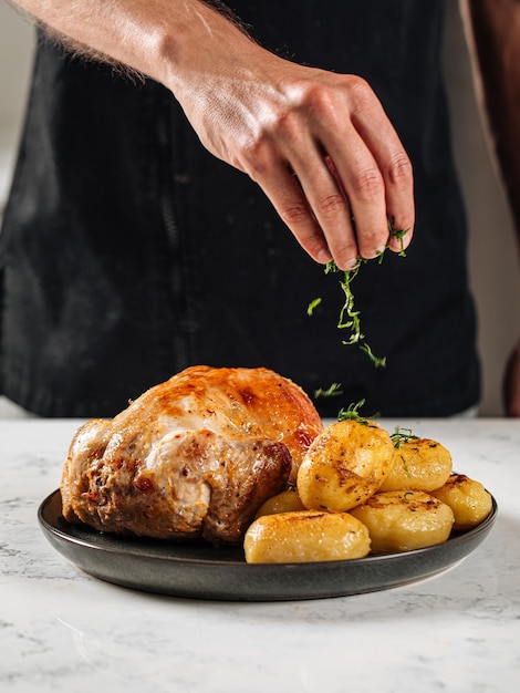 Foto chef che prepara pollo al forno con patate