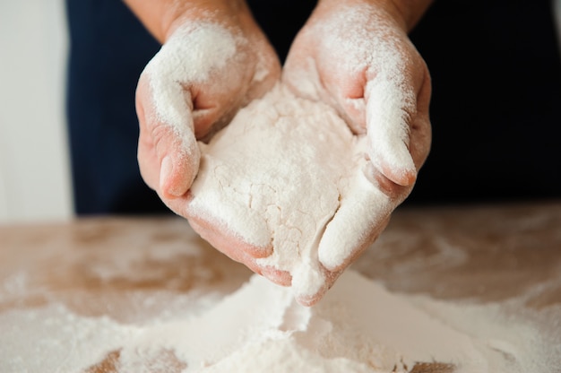 Foto chef prepara l'impasto. processo di cottura, lavorare con la farina.