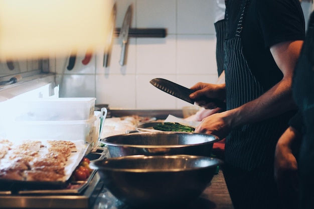 Foto chef che prepara il cibo al bancone della cucina.