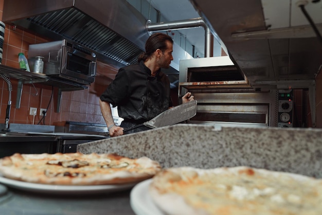 Foto chef che prepara la pizza italiana nella cucina di un ristorante