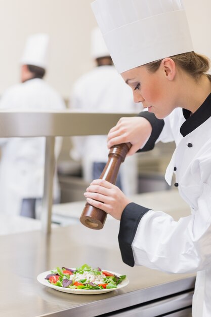 Chef preparing a salad with pepper