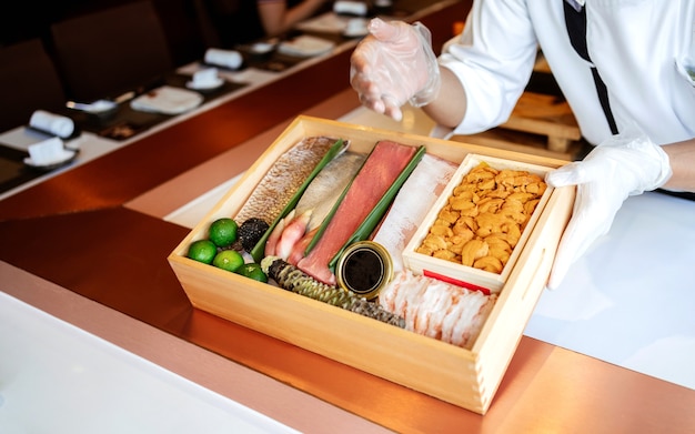 Photo the chef presents the premium fresh ingredients in a wooden box before making the omakase meal