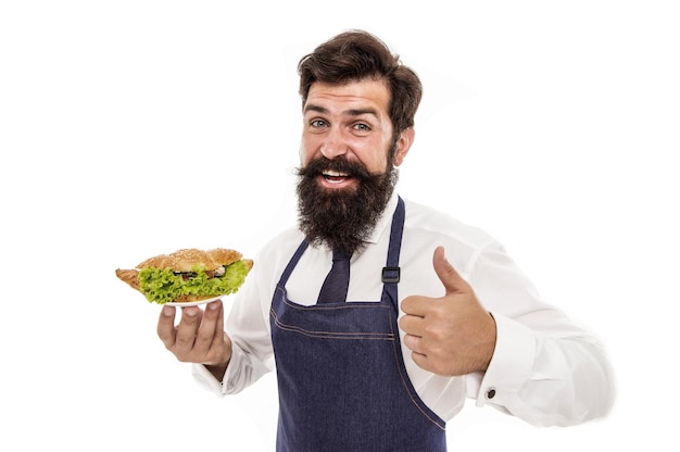 Photo chef proud of croissant meal man bearded waiter wear apron carry plate with dish delicious croissant cafe concept guy serving croissant stuffed with lettuce and fresh vegetables healthy food