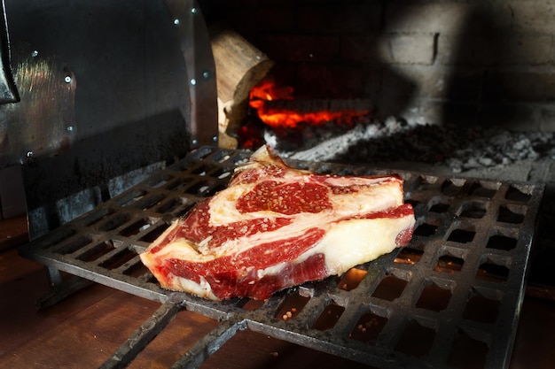 the chef puts the wetaged steak in the stone oven