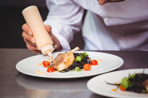 Chef putting sauce on a dish