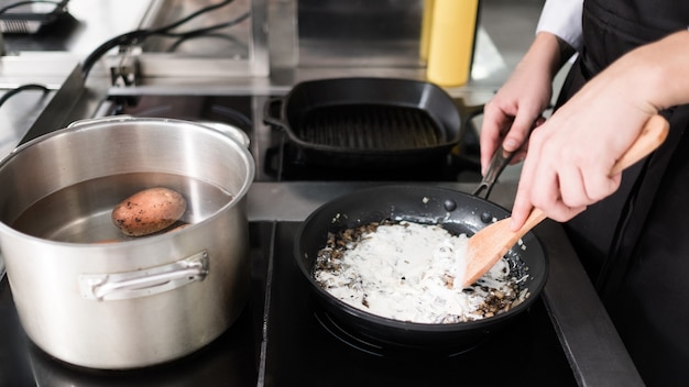 Foto chef una cucina del ristorante che cucina un pasto. un professionista al lavoro. il capolavoro del cibo è in arrivo.