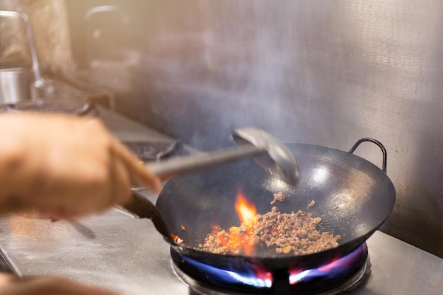 Chef roerbak in wok Dramatisch koken met vuur hard