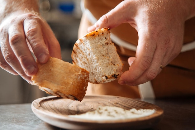 Foto lo chef strofina due pezzi di pane tostato