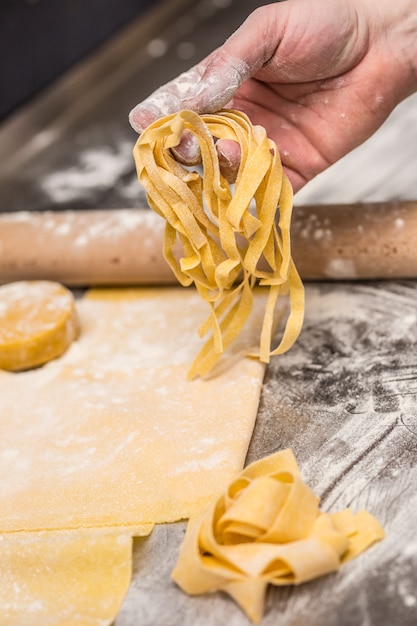 シェフの手がパスタの生地を準備します。