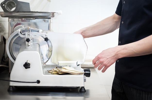 Chef's work on a slicer slicing vegetables