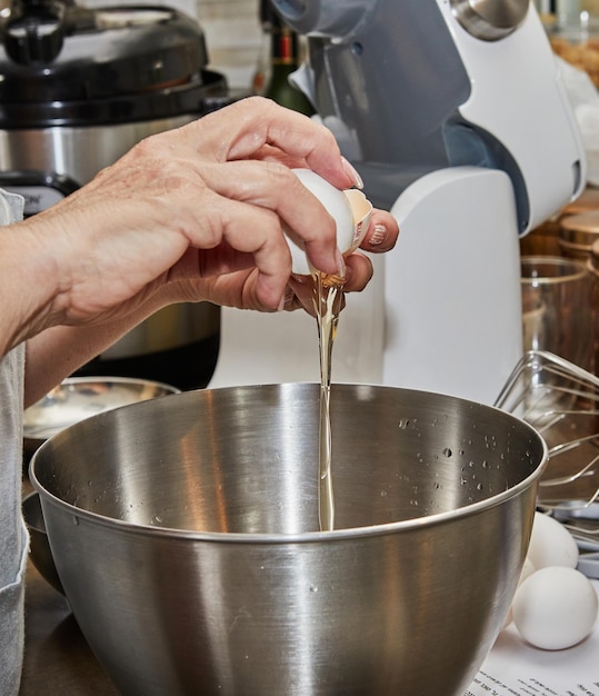 Chef scheidt de dooier van het eiwit om de taart te maken